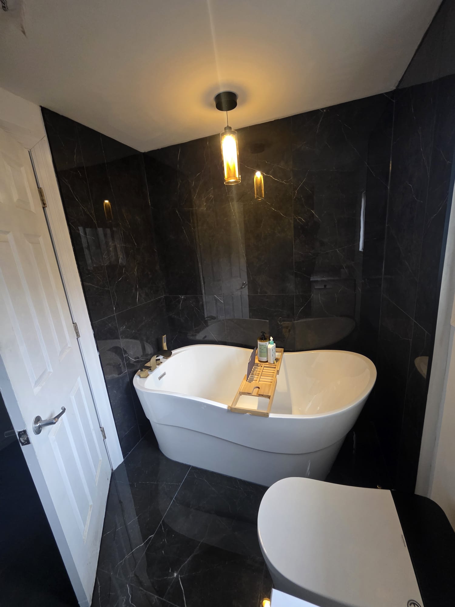 Completed Scarborough bathroom remodel with a freestanding tub and dark marble-look tile