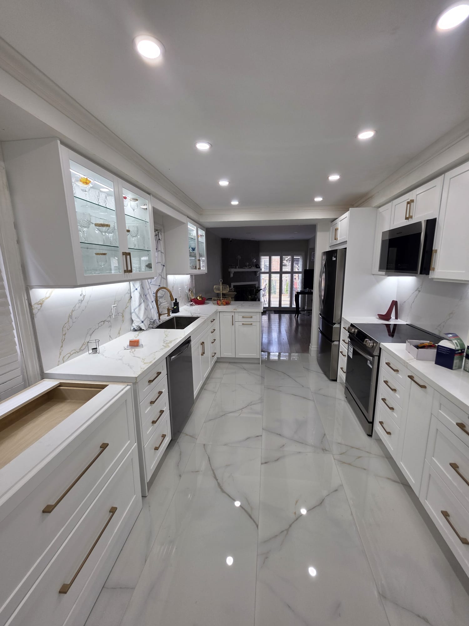 Completed Scarborough kitchen remodel with white cabinetry, marble-look surfaces, and integrated appliances